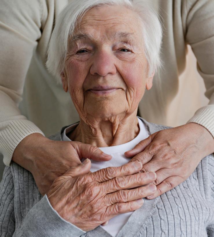 Una mujer mayor siendo abrazada por su nieta