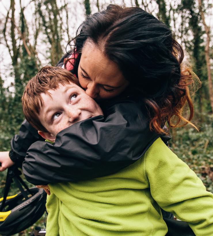 Mamá besando a su hijo durante un paseo en bicicleta.